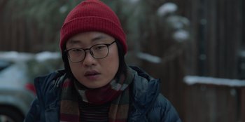 Movie still from “Love Hard” (2021), directed by Hernán Jiménez – A man wearing a red hat and glasses; Close Up shot, Over the shoulder angle