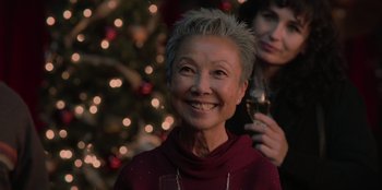 Movie still from “Love Hard” (2021), directed by Hernán Jiménez – An older woman with a wine glass in front of a christmas tree; Close Up shot, Over the shoulder angle