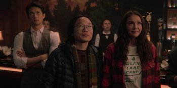 Movie still from “Love Hard” (2021), directed by Hernán Jiménez – A group of people standing in front of a painting; Medium shot, Over the shoulder angle