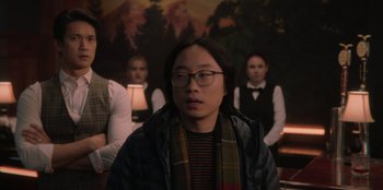 Movie still from “Love Hard” (2021), directed by Hernán Jiménez – A group of people standing in front of a painting; Medium shot, Over the shoulder angle