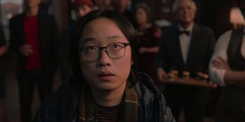 Movie still from “Love Hard” (2021), directed by Hernán Jiménez – A man with glasses is looking into the distance; Close Up shot, Over the shoulder angle