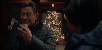 Movie still from “Love Hard” (2021), directed by Hernán Jiménez – An older man is drinking a cup of hot chocolate; Close Up shot, Over the shoulder angle