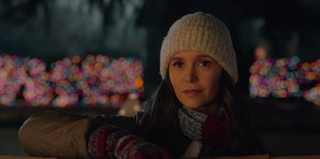 Movie still from “Love Hard” (2021), directed by Hernán Jiménez – A woman wearing a white hat and a white scarf; Close Up shot, Over the shoulder angle