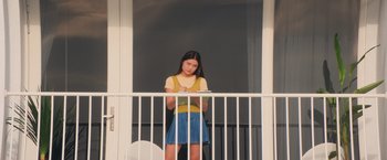 Movie still from “Love in Taipei” (2023), directed by Arvin Chen – A woman standing on a balcony looking at the camera; Medium shot, Low angle