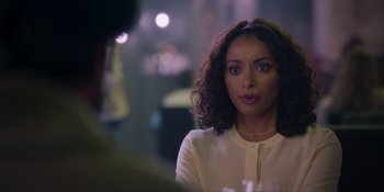 Movie still from “Love in the Villa” (2022), directed by Mark Steven Johnson – A person with curly black hair; Close Up shot, Over the shoulder angle