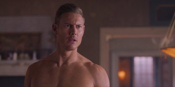 Movie still from “Love in the Villa” (2022), directed by Mark Steven Johnson – A man with no shirt is standing in a room; Close Up shot, Over the shoulder angle