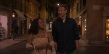 Movie still from “Love in the Villa” (2022), directed by Mark Steven Johnson – A man and a woman standing next to each other on a street; Medium shot, Over the shoulder angle