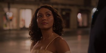 Movie still from “Love in the Villa” (2022), directed by Mark Steven Johnson – A person with curly hair wearing a dress; Close Up shot, Over the shoulder angle