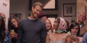 Movie still from “Love in the Villa” (2022), directed by Mark Steven Johnson – A group of people standing next to each other in a room; Medium shot, Over the shoulder angle