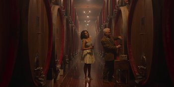 Movie still from “Love in the Villa” (2022), directed by Mark Steven Johnson – A man and a woman are standing in a wine cellar; Wide shot, Low angle