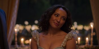Movie still from “Love in the Villa” (2022), directed by Mark Steven Johnson – A woman in a dress is smiling for the camera; Close Up shot, Over the shoulder angle