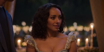 Movie still from “Love in the Villa” (2022), directed by Mark Steven Johnson – A person with curly hair wearing a dress; Close Up shot, Over the shoulder angle