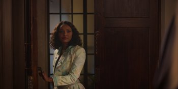 Movie still from “Love in the Villa” (2022), directed by Mark Steven Johnson – A woman standing in front of an open door; Medium shot, Over the shoulder angle