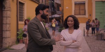 Movie still from “Love in the Villa” (2022), directed by Mark Steven Johnson – A man and a woman are standing in the middle of a street; Medium shot, Over the shoulder angle