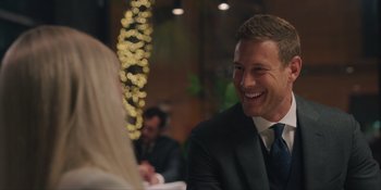 Movie still from “Love in the Villa” (2022), directed by Mark Steven Johnson – A man in a suit and tie smiling at a woman; Close Up shot, Over the shoulder angle