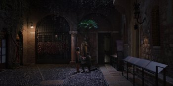 Movie still from “Love in the Villa” (2022), directed by Mark Steven Johnson – A man kneeling down next to a woman in front of a tree; Extreme Wide shot, High angle