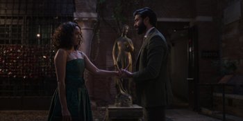 Movie still from “Love in the Villa” (2022), directed by Mark Steven Johnson – A man and a woman holding hands in front of a statue; Medium shot, Over the shoulder angle