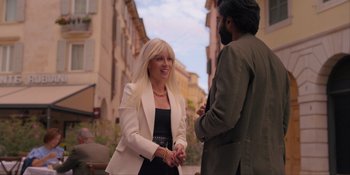 Movie still from “Love in the Villa” (2022), directed by Mark Steven Johnson – A woman in a black dress and a man in a white jacket talking; Medium shot, Over the shoulder angle