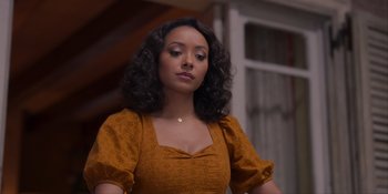 Movie still from “Love in the Villa” (2022), directed by Mark Steven Johnson – A woman in an orange dress is looking down; Close Up shot, Over the shoulder angle