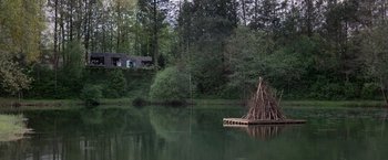 Movie still from “Loving Adults” (2022), directed by Barbara Topsøe-Rothenborg – A raft floating on the water near the shore; Extreme Wide shot, Low angle