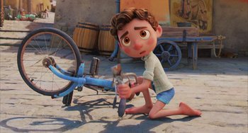 Movie still from “Luca” (2021), directed by Enrico Casarosa – A boy is kneeling down next to a bicycle; Wide shot, High angle