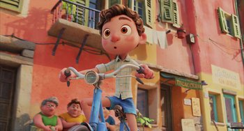 Movie still from “Luca” (2021), directed by Enrico Casarosa – A boy riding a bike in front of a building; Wide shot, High angle