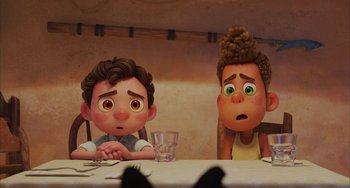 Movie still from “Luca” (2021), directed by Enrico Casarosa – A couple of people sitting at a table with a glass of water; Close Up shot, Over the shoulder angle