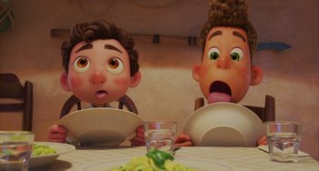 Movie still from “Luca” (2021), directed by Enrico Casarosa – A couple of people sitting at a table with plates; Close Up shot, Over the shoulder angle