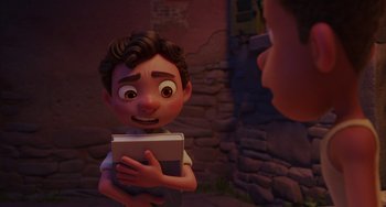 Movie still from “Luca” (2021), directed by Enrico Casarosa – A boy holding a book in front of another boy; Medium shot, Over the shoulder angle