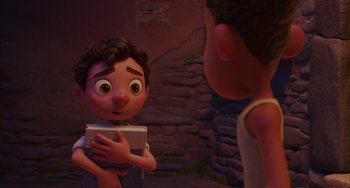 Movie still from “Luca” (2021), directed by Enrico Casarosa – A boy is holding a book while another boy looks at him; Close Up shot, Over the shoulder angle