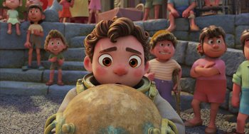Movie still from “Luca” (2021), directed by Enrico Casarosa – A cartoon of a boy holding an object in front of a group of people; Medium shot, High angle