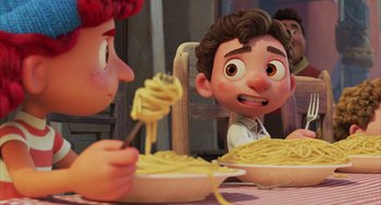 Movie still from “Luca” (2021), directed by Enrico Casarosa – A couple of people sitting at a table with a bowl of spaghetti; Medium shot, Over the shoulder angle