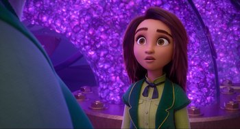 Movie still from “Luck” (2022), directed by Peggy Holmes – A woman with a green shirt is standing in front of a purple background; Close Up shot, Over the shoulder angle