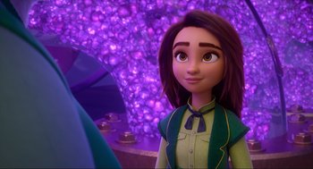 Movie still from “Luck” (2022), directed by Peggy Holmes – A woman with long brown hair is standing in front of a purple background; Close Up shot, Over the shoulder angle