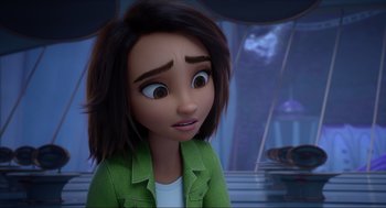 Movie still from “Luck” (2022), directed by Peggy Holmes – A woman with brown hair and a green jacket looking sad; Close Up shot, Over the shoulder angle