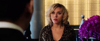 Movie still from “Lucy” (2014), directed by Luc Besson – A woman in a leopard print jacket looking at the camera; Close Up shot, Over the shoulder angle