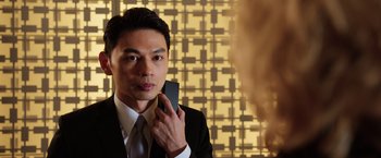 Movie still from “Lucy” (2014), directed by Luc Besson – A man holding a cell phone up to his face; Close Up shot, Low angle