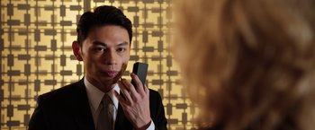 Movie still from “Lucy” (2014), directed by Luc Besson – A man holding a cell phone up to his face; Close Up shot, Low angle