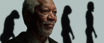 Movie still from “Lucy” (2014), directed by Luc Besson – An older man is looking at the camera with his shadow behind him; Close Up shot, Low angle