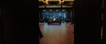 Movie still from “Lucy” (2014), directed by Luc Besson – A man sitting on a couch in front of a large window; Extreme Wide shot, High angle