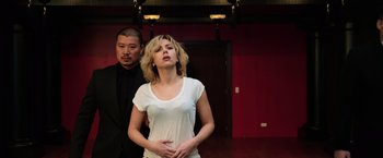 Movie still from “Lucy” (2014), directed by Luc Besson – A man and a woman standing next to each other in a room; Medium shot, Low angle
