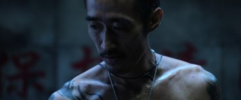 Movie still from “Lucy” (2014), directed by Luc Besson – A person with a tattoo on his chest; Close Up shot, High angle