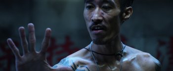 Movie still from “Lucy” (2014), directed by Luc Besson – A person with a tattoo on his chest; Close Up shot, Low angle