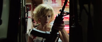 Movie still from “Lucy” (2014), directed by Luc Besson – A woman holding an ar - 1 5 style rifle in her hands; Close Up shot, Low angle