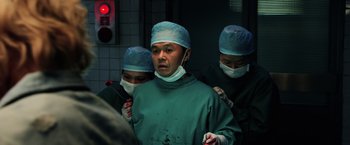 Movie still from “Lucy” (2014), directed by Luc Besson – A group of surgeons in a hospital operating room; Medium shot, Low angle