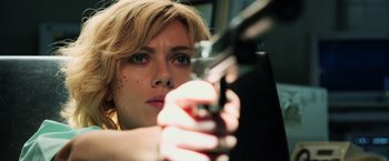 Movie still from “Lucy” (2014), directed by Luc Besson – A person holding a gun; Close Up shot, Low angle