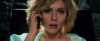 Movie still from “Lucy” (2014), directed by Luc Besson – A person talking on a cell phone; Close Up shot, Low angle