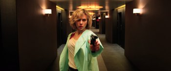 Movie still from “Lucy” (2014), directed by Luc Besson – A woman holding a cell phone in her hand; Medium shot, Overhead angle
