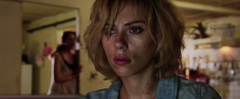 Movie still from “Lucy” (2014), directed by Luc Besson – A person with short blonde hair; Close Up shot, Over the shoulder angle