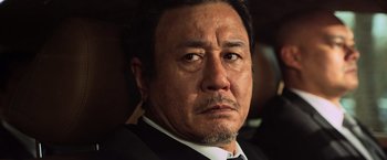 Movie still from “Lucy” (2014), directed by Luc Besson – A person wearing a suit and tie; Close Up shot, Low angle